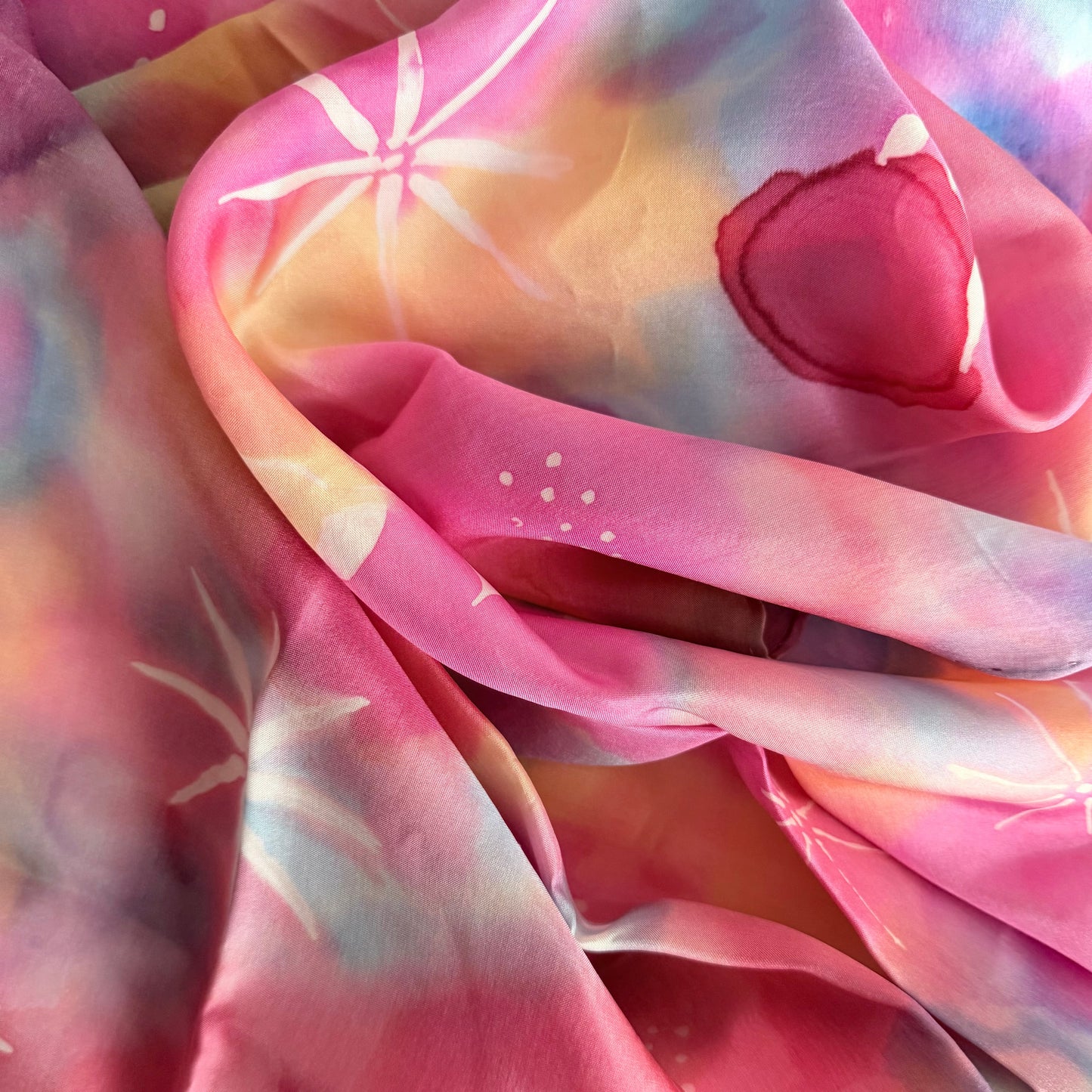 Colorful fabric with heart and star patterns in pink, purple, and orange.